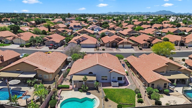 aerial perspective of suburban area featuring a pool and a mountainous background