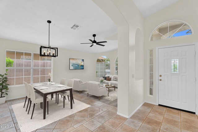 dining room featuring a chandelier, arched walkways, baseboards, and a ceiling fan