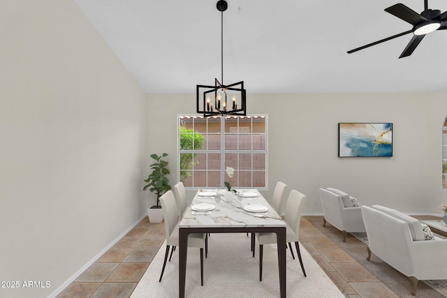 dining space featuring a chandelier, ceiling fan, baseboards, and light tile patterned flooring