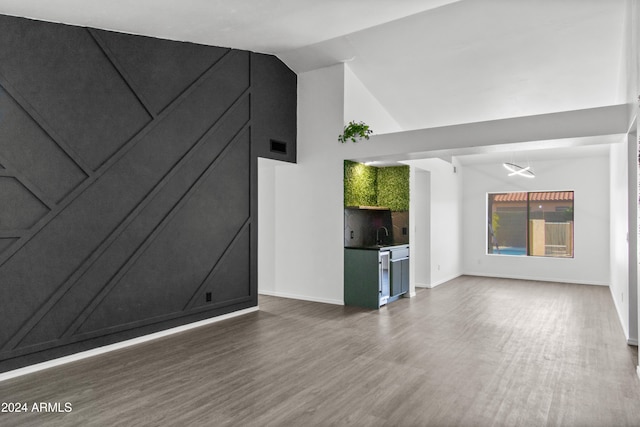 unfurnished living room with lofted ceiling and dark wood-type flooring