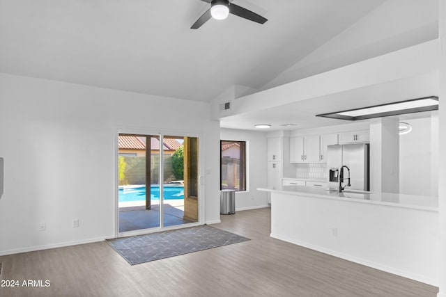 kitchen featuring dark hardwood / wood-style flooring, ceiling fan, stainless steel fridge with ice dispenser, white cabinetry, and lofted ceiling