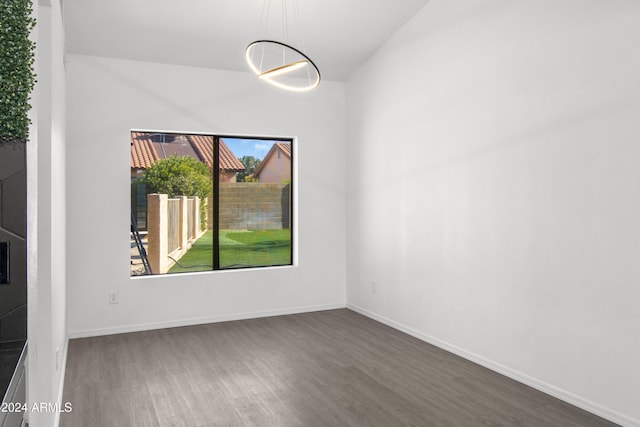 empty room featuring dark hardwood / wood-style flooring and vaulted ceiling