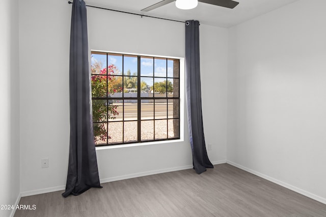 unfurnished room with ceiling fan and hardwood / wood-style flooring