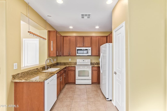 kitchen with white appliances, light stone countertops, light tile patterned flooring, and sink