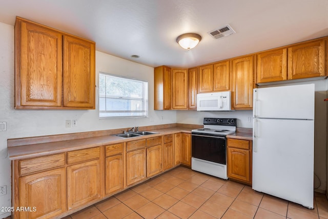 kitchen with sink, white appliances, and light tile patterned floors