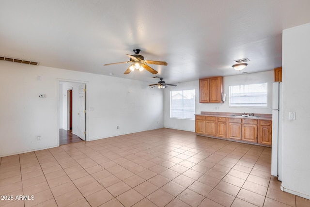 kitchen featuring white refrigerator, light tile patterned floors, and ceiling fan