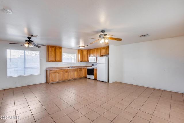 kitchen featuring ceiling fan, sink, light tile patterned floors, and white appliances