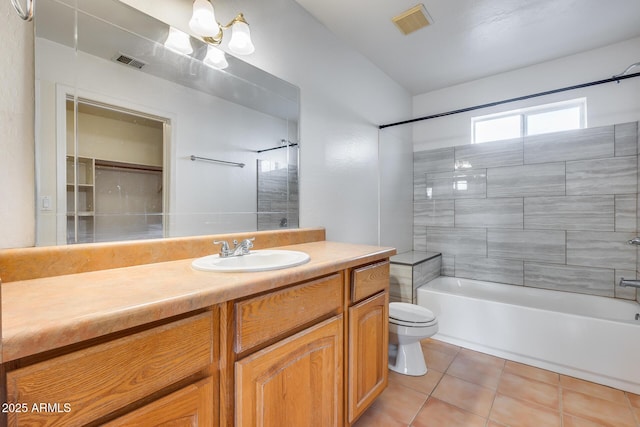 full bathroom featuring tile patterned flooring, tiled shower / bath, vanity, and toilet