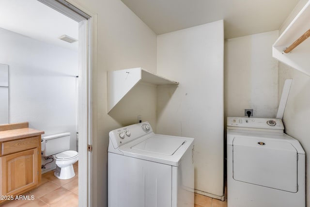 laundry area featuring light tile patterned flooring and washer and clothes dryer