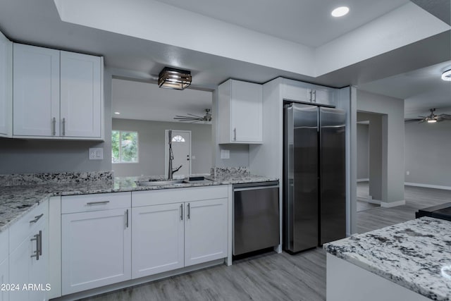 kitchen with ceiling fan, white cabinetry, and stainless steel appliances