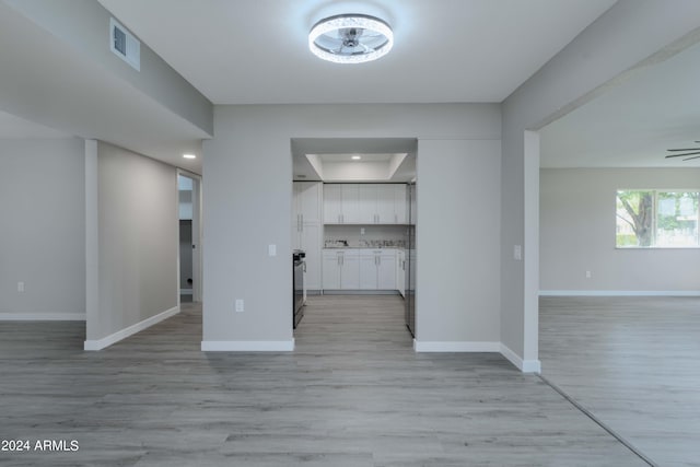 interior space featuring light wood-type flooring, visible vents, and baseboards