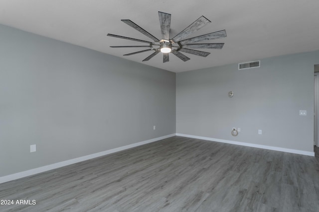 unfurnished room with light wood-style flooring, a ceiling fan, visible vents, and baseboards