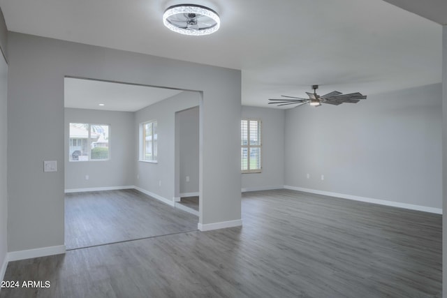 interior space with a healthy amount of sunlight, ceiling fan, baseboards, and wood finished floors