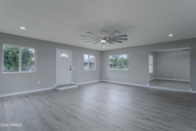 interior space featuring recessed lighting, light wood-type flooring, a ceiling fan, and baseboards