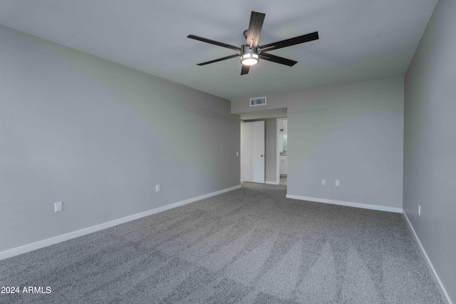 carpeted empty room featuring a ceiling fan, visible vents, and baseboards