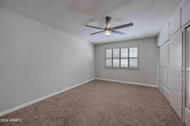 unfurnished bedroom featuring a ceiling fan, a closet, baseboards, and carpet flooring