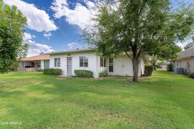 ranch-style home with a front yard and central air condition unit