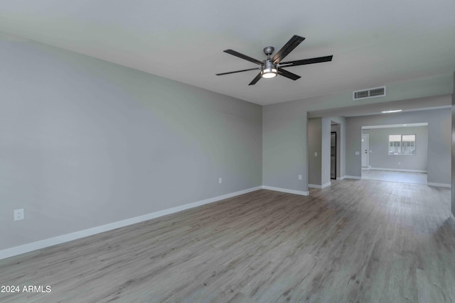 spare room with light wood-style floors, visible vents, ceiling fan, and baseboards