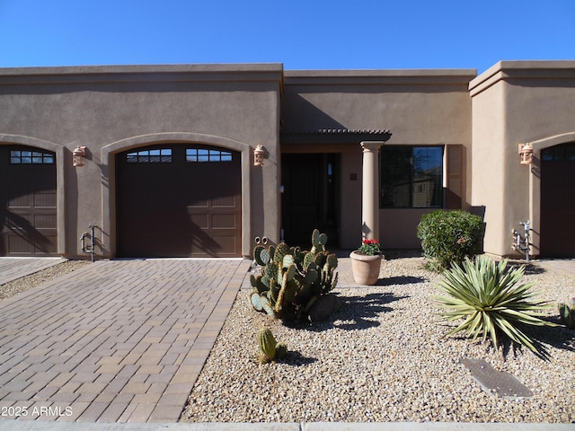 pueblo revival-style home with a garage