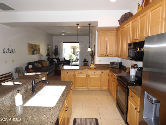 kitchen with sink, dark stone countertops, ceiling fan, pendant lighting, and black appliances