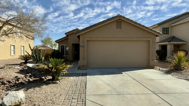 view of front of property featuring a garage, concrete driveway, and stucco siding