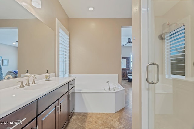 bathroom with a stall shower, a healthy amount of sunlight, connected bathroom, vanity, and a bath