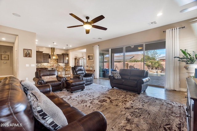 living area with recessed lighting, visible vents, a ceiling fan, tile patterned flooring, and baseboards