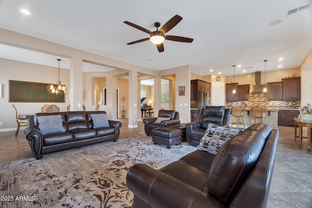 living area featuring recessed lighting, visible vents, baseboards, and ceiling fan with notable chandelier