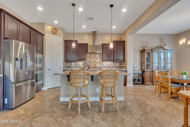 kitchen with light stone counters, visible vents, appliances with stainless steel finishes, dark brown cabinets, and wall chimney exhaust hood