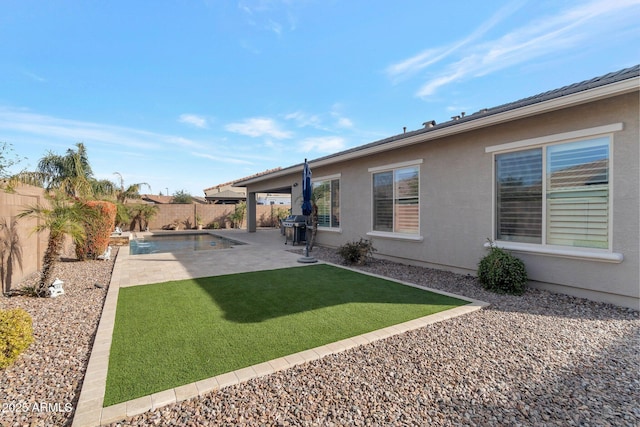 back of property featuring a lawn, a patio area, a fenced backyard, and stucco siding