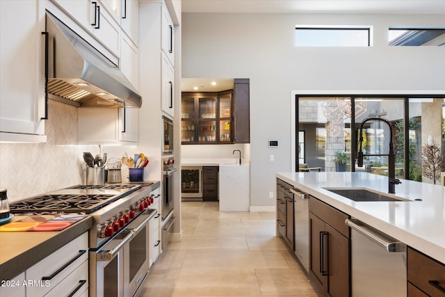 kitchen featuring wine cooler, appliances with stainless steel finishes, sink, and white cabinets