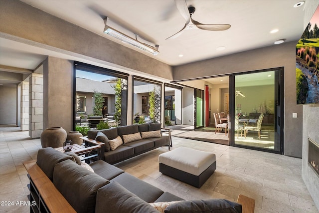 living room with a fireplace and ceiling fan