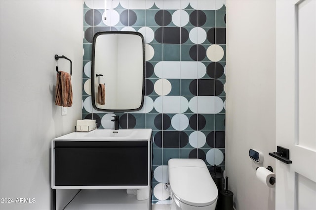 bathroom with vanity, tile walls, and toilet