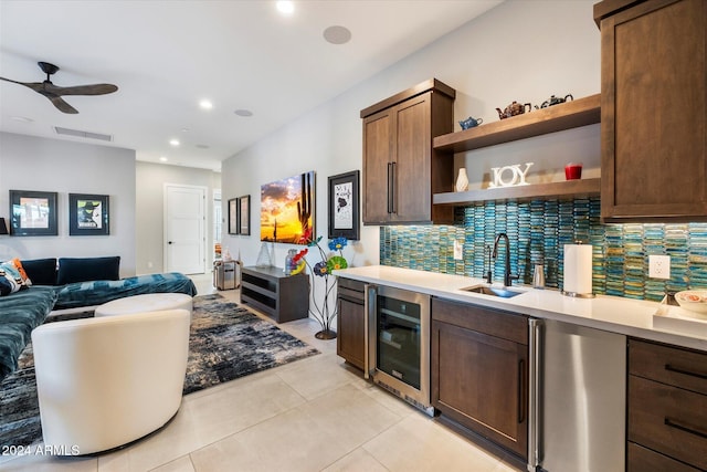 kitchen with sink, light tile patterned floors, ceiling fan, beverage cooler, and backsplash