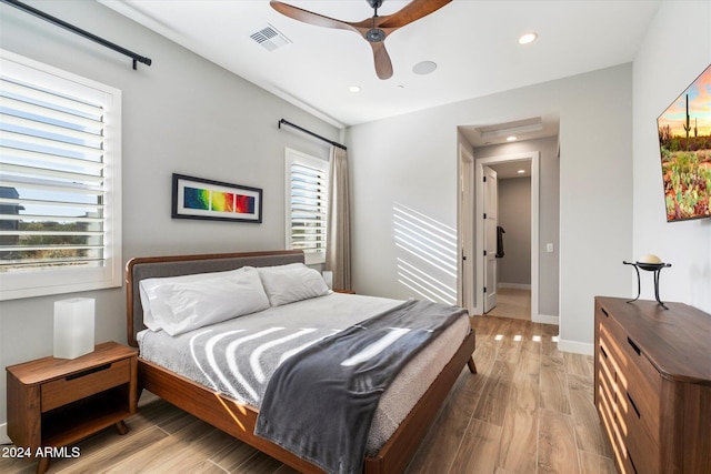 bedroom with multiple windows, ceiling fan, and light hardwood / wood-style floors