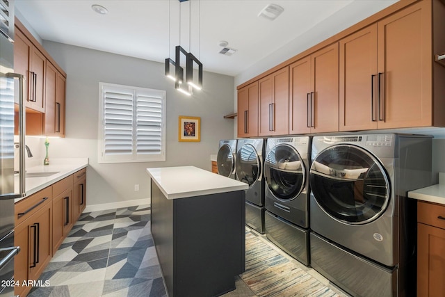 clothes washing area with sink, cabinets, and washer and dryer