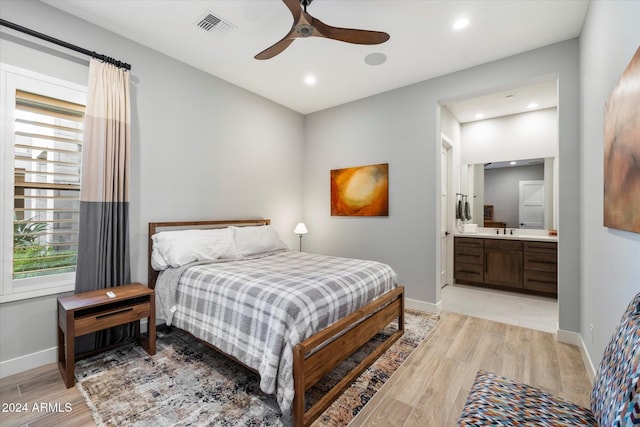 bedroom featuring ceiling fan, sink, ensuite bath, and light hardwood / wood-style flooring