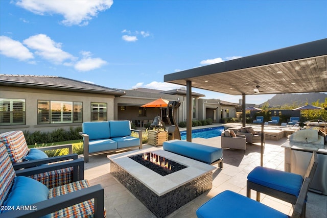 view of patio with an outdoor living space with a fire pit and ceiling fan