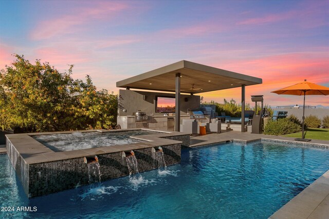 pool at dusk featuring pool water feature and area for grilling