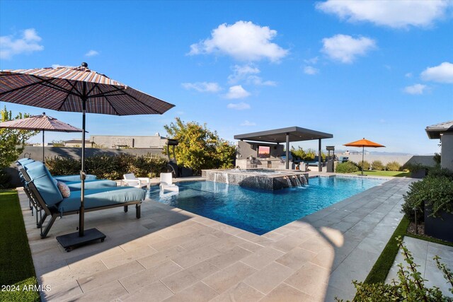 view of swimming pool with pool water feature, an in ground hot tub, and a patio