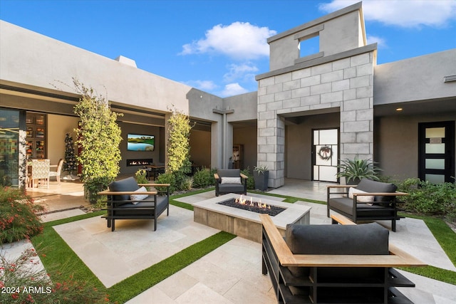 view of patio with an outdoor living space with a fire pit