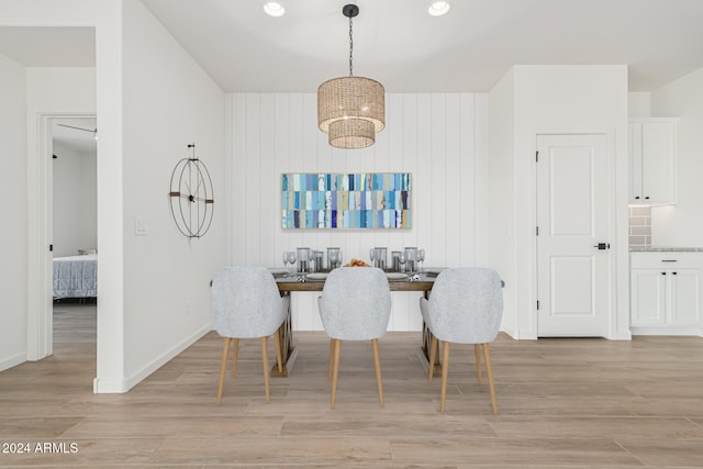 dining area with wood walls and light hardwood / wood-style floors