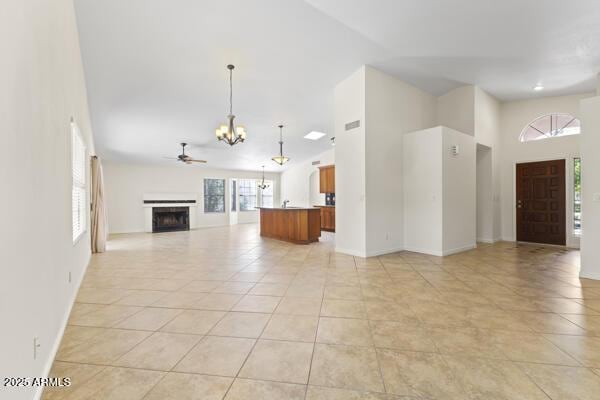 5450 E Paradise Ln, Scottsdale, AZ 85254 - unfurnished living room with a chandelier, healthy amount of natural light, a towering ceiling, a fireplace, and ceiling fan