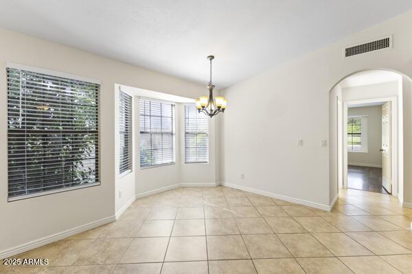 5450 E Paradise Ln, Scottsdale, AZ 85254 - empty room with a chandelier, arched walkways, and light tile patterned floors