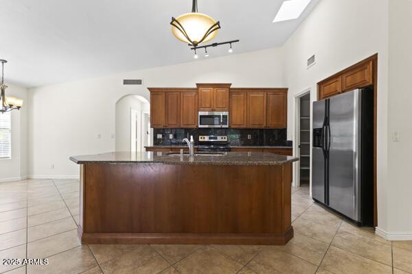 5450 E Paradise Ln, Scottsdale, AZ 85254 - kitchen featuring appliances with stainless steel finishes, backsplash, lofted ceiling, light tile patterned floors, and hanging light fixtures