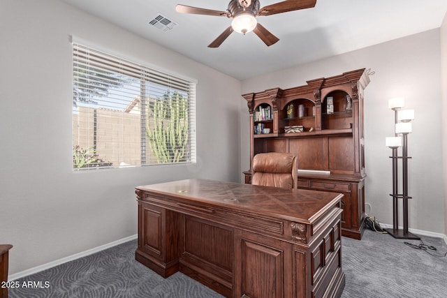 office featuring visible vents, dark carpet, baseboards, and ceiling fan