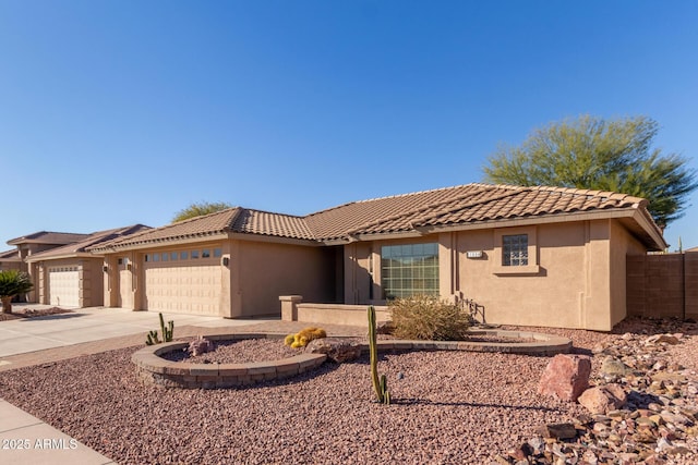 view of front of house featuring driveway, a tiled roof, a garage, and stucco siding