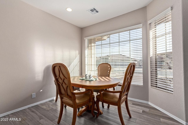 dining space with baseboards, visible vents, and wood finished floors