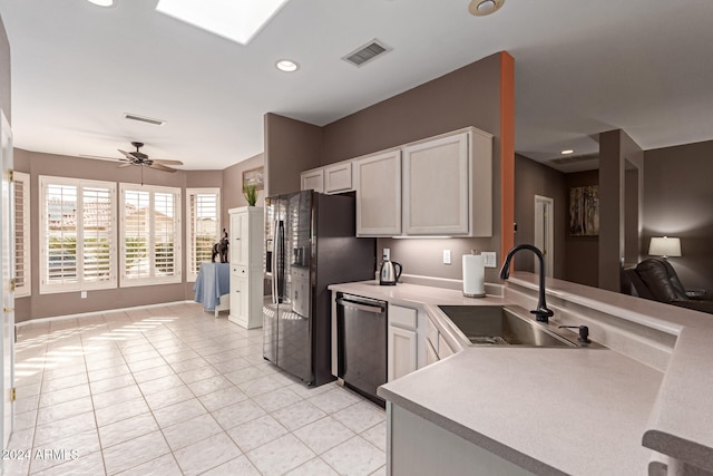 kitchen featuring black fridge, stainless steel dishwasher, ceiling fan, sink, and white cabinetry