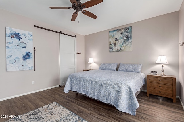 bedroom with dark hardwood / wood-style flooring, a barn door, and ceiling fan